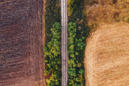 Old railroad track through countryside in autumn, aerial view from drone povの写真素材