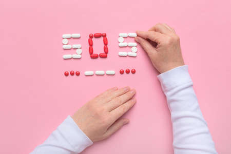 Birth control concept with pills spelling SOS in Morse code, flat lay top viewの写真素材