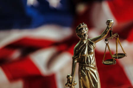Law and Justice in United States of America, statue of Lady Justice with USA flag in background, selective focusの写真素材