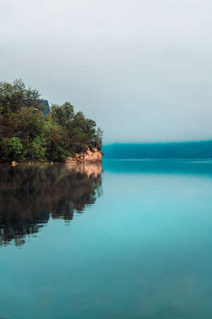Lake Bohinj in misty august morning, beautiful glacial lake situated in Slovenian Triglav national parkの写真素材