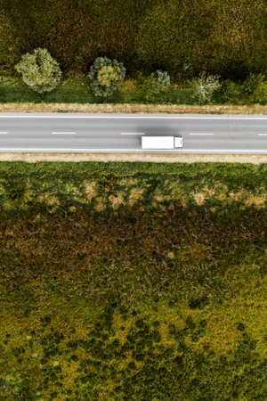 Aerial view of lorry truck on the road through countryside in sunny summer afternoonの写真素材