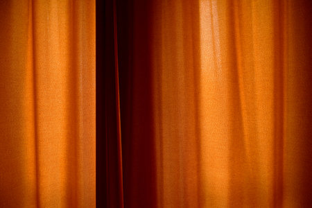Behind closed curtains, wrinkled window blinds as backgroundの写真素材