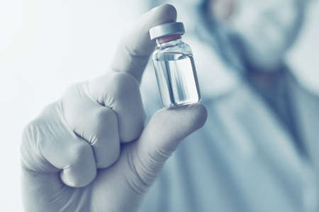 Medical doctor holding vaccine vial for virus vaccination concept, selective focusの写真素材