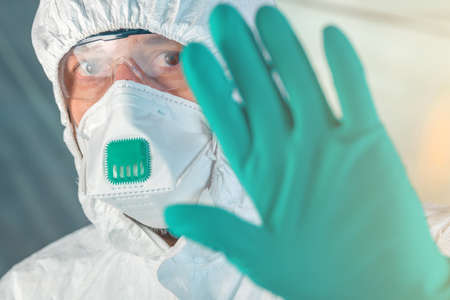 quarantine concept with epidemiologist gesturing stop hand sign, selective focus on eyeの写真素材