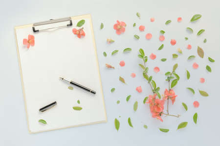 Blank paper on clipboard note pad with floral decoration, flat lay mock up copy space for springtime seasonの写真素材
