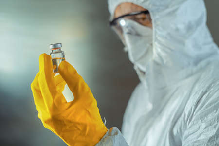 Medical worker holding vaccine serum sterile bottle, selective focusの写真素材