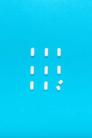 Film coated white oval tablets flat lay top view on blue backgroundの写真素材