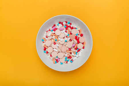 Plate full of tablets, pills and capsule medication - top view flat lay arrangementの写真素材
