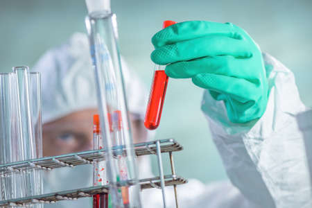 Virologist healthcare professional analyzing blood test sample in lab tubes, close up of medical...