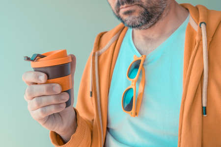 Morning coffee to go, man holding plastic cup, selective focus