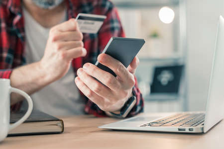 Freelancer shopping online with smartphone app and credit card from small business home office, selective focusの写真素材