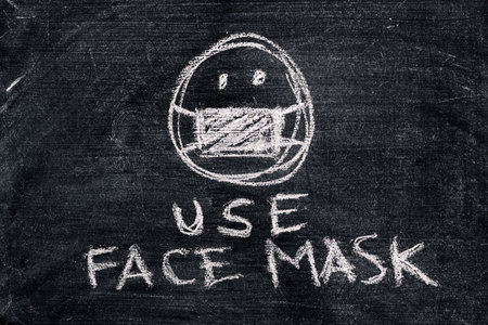 Use face mask, simple chalk drawing on dirty blackboardの写真素材