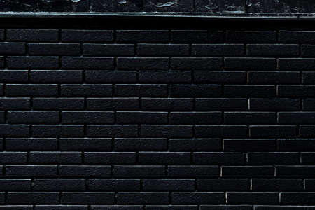 Background of black brick wall, dark pattern and urban textureの写真素材