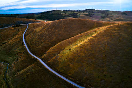 Aerial view of beautiful Zlatibor region landscape with asphalt road passing through from drone pov....