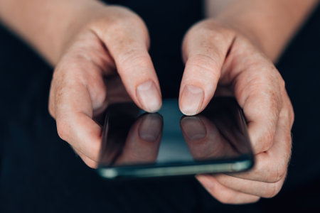 Female hands using modern mobile phone to type text message, selective focusの写真素材