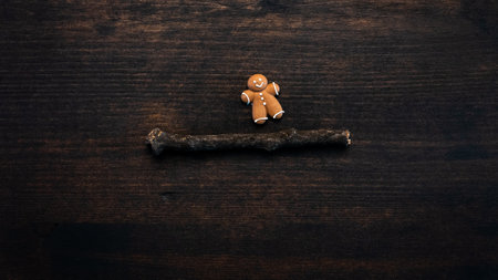 Gingerbread man cookie flat lay top view on dark wooden background with copy space