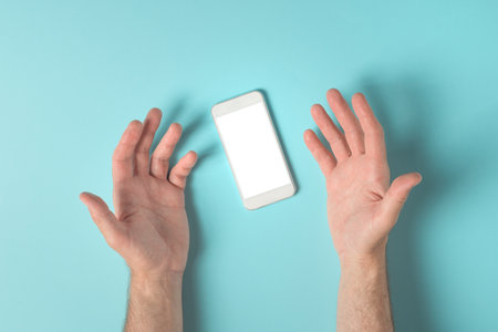 Frustrated male hands over smartphone screen mock up copy space, top viewの写真素材