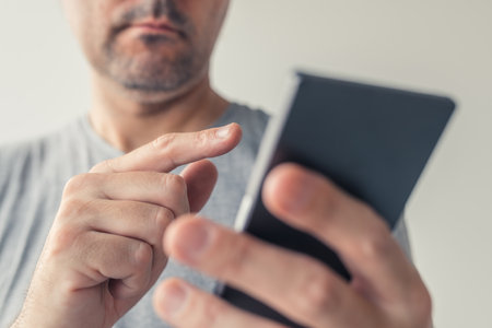 Close up of male hands typing text message on smartphone, selective focus