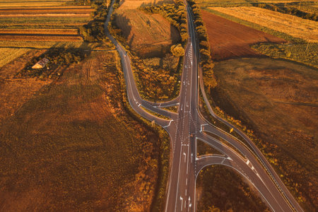 Vehicles on the road intersection through countryside landscape from drone povの写真素材