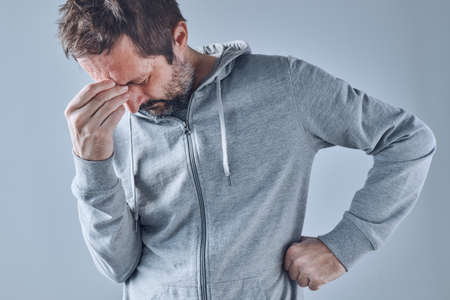 Adult caucasian man with severe tension headache, painful facial expression