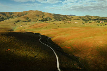 Drone photography of winding road through beautiful Zlatibor mountain landscape in early summer sunriseの写真素材