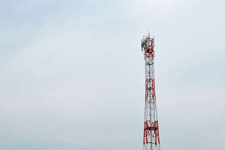 Telecommunication tower with antennas and signal repeaters against overcast sky as copy spaceの写真素材