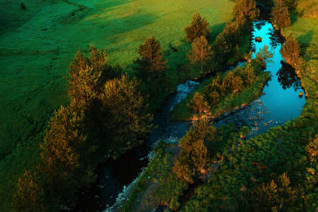 Aerial view of mountain creek winding through beautiful grassy landscape on Zlatibor, Serbia - drone...