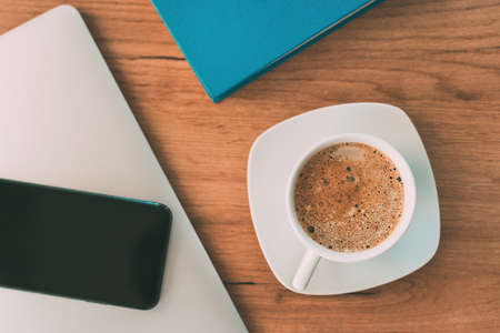 Morning coffee before starting the freelance job, coffee cup on home office desk, top viewの写真素材