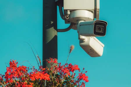 CCTV security cameras at town square post decorated with some flowers, selective focusの写真素材