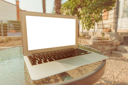 Working on vacation, laptop mock up screen on apartment balcony in summer morning, selective focusの写真素材