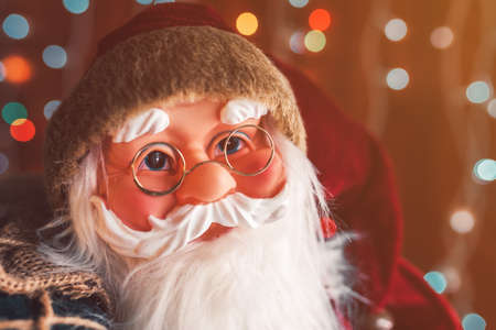Santa Claus dummy toy with festive colorful string light bokeh background, selective focus