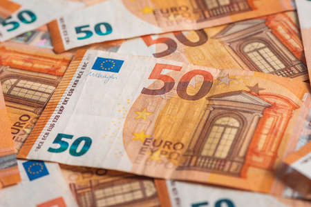 Fifty euros paper banknotes scattered on the table, top view as financial and business background, selective focusの写真素材