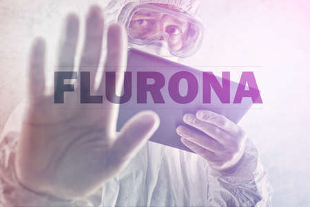 Flurona, infection with both seasonal flu and Covid 19 coronavirus, conceptual image with epidemiologist gesturing stop hand sign, selective focusの写真素材
