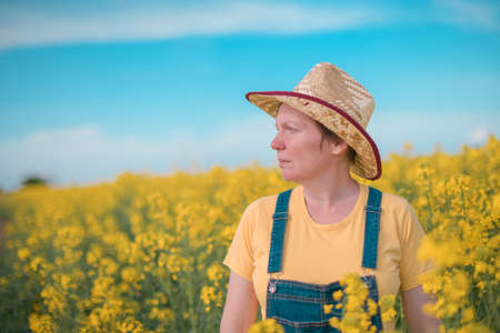Portrait of female farmer agronomist in blooming rapeseed crops field, selective focusの写真素材