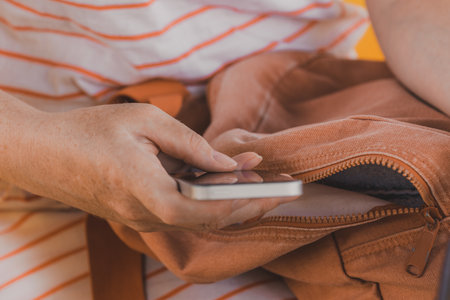 Woman using smartphone outdoors, close up of female hands with mobile phone, selective focusの写真素材