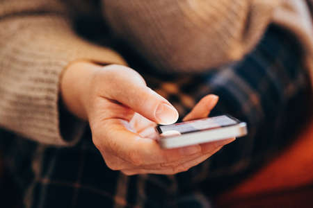 Fomo, fear of missing out on information, events or experiences makes people use their smartphones more than usual, selective focusの写真素材