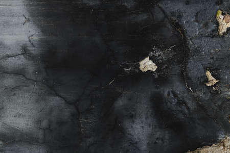 Worn damaged dark black facade as background, urban patterns and textures