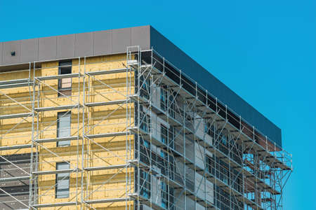 Mineral wool insulation of high-rise apartment building in residential district, construction...