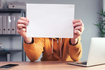Freelancer holding blank white paper as mockup copy space for quote text, selective focusの写真素材