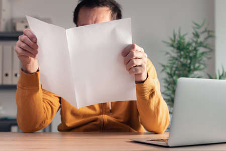 Freelancer with produced business report mockup in home office interior, selective focus