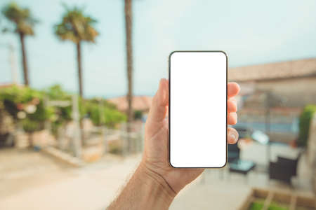 Summer vacation holiday and mobile smart phone with blank mockup screen, man holding device at...