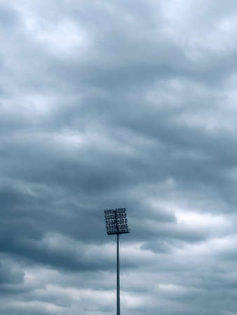 Stadium lights against dark ominous sky before the stormの写真素材