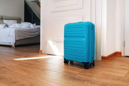 Blue travel suitcase in hotel apartment, selective focusの写真素材