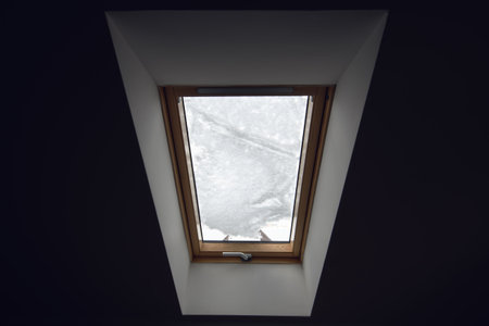 Roof window covered in snow in winter season afternoon