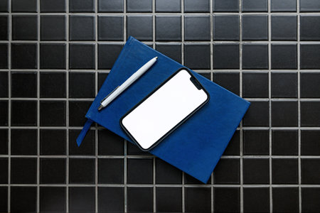 Smartphone mockup with guestbook and pencil in apartment room, top viewの写真素材