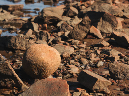 Round ball shaped granite rock at Kattegat sea shoreline in Halmstad, Sweden. Selective focus.の写真素材