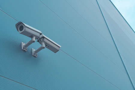 Outdoor surveillance security camera mounted on industrial building wall to monitor the activity outside the premisesの写真素材