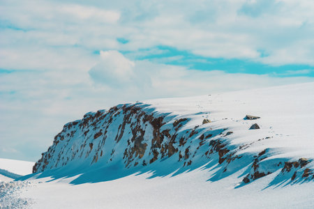 Winter season landscape, mountain hill covered in pure white snow with blue sky in backgroundの写真素材