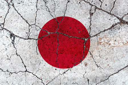 Japan flag on cracked concrete surface after earthquake, conceptual imageの写真素材