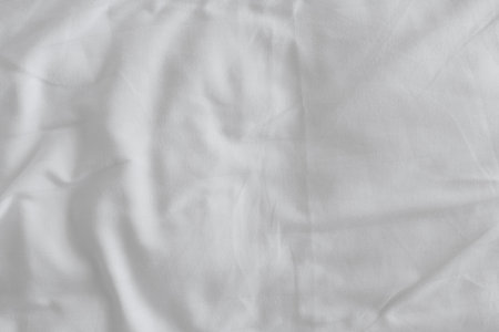 Texture of crumpled white bed sheets as background, top view